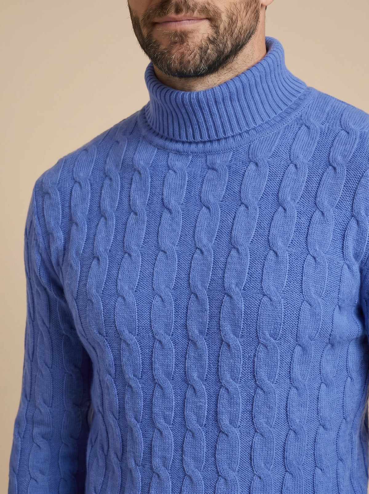 Detalle del cuello alto y de las trenzas del jersey azul
