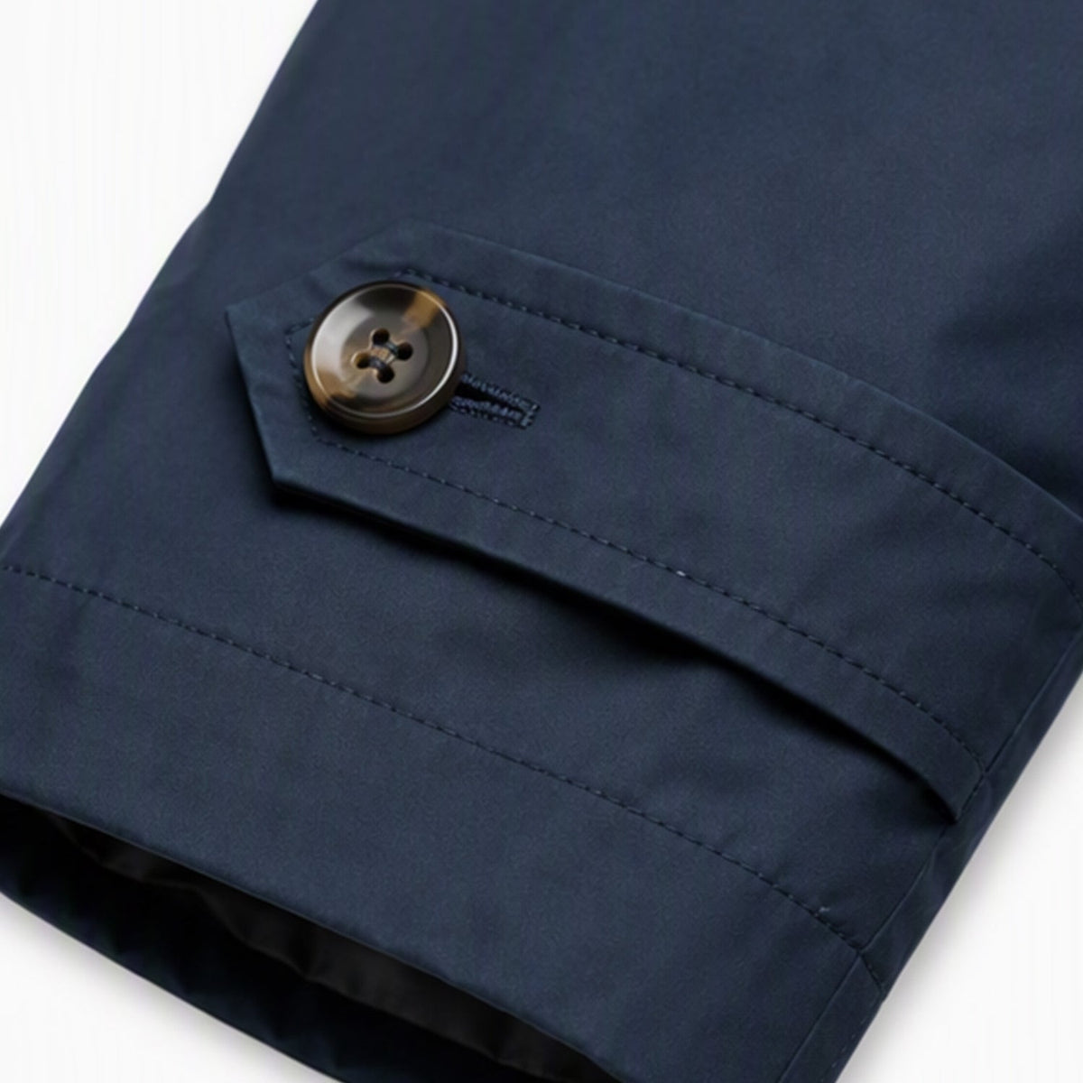 Detalle del puño con trabilla y botón de la gabardina Enzo